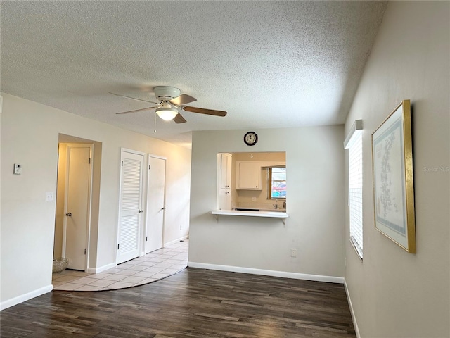 unfurnished living room with ceiling fan, light hardwood / wood-style flooring, and a textured ceiling