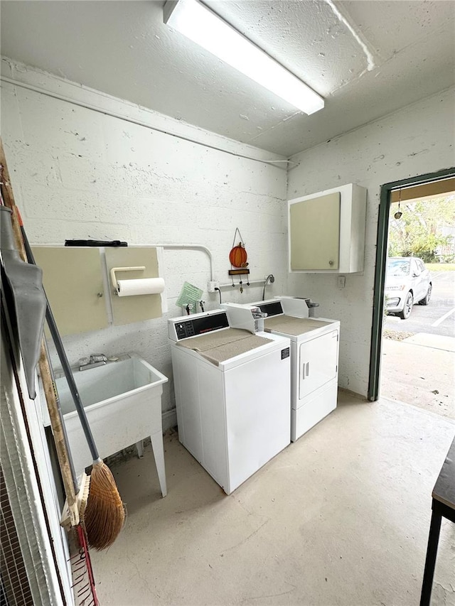 clothes washing area with washer and clothes dryer and sink