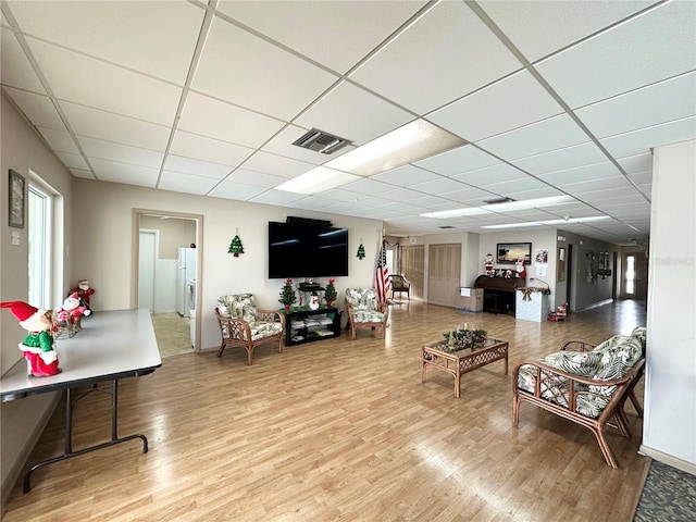 living room with hardwood / wood-style floors and a drop ceiling