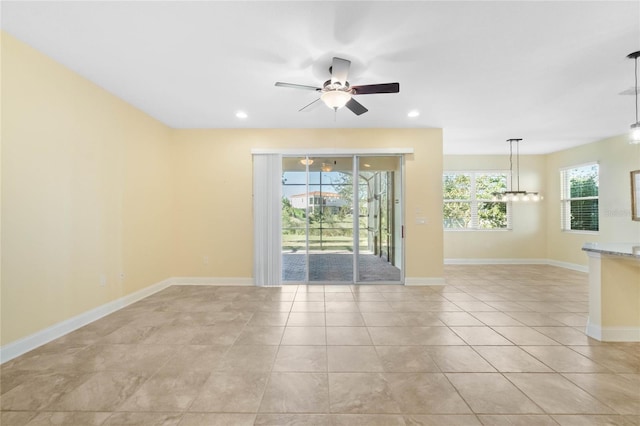 empty room with ceiling fan and light tile patterned floors