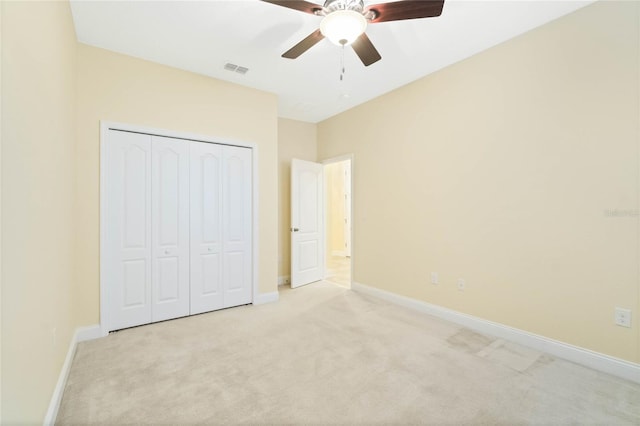 unfurnished bedroom with ceiling fan, a closet, and light carpet