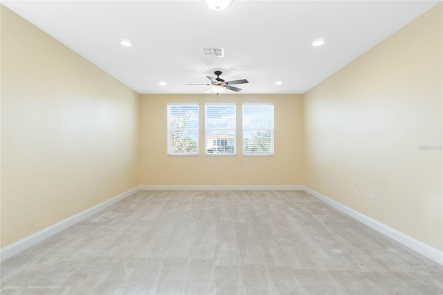 spare room featuring light carpet and ceiling fan