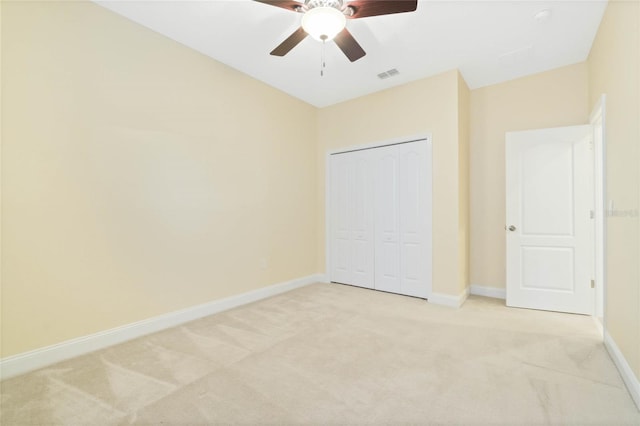 unfurnished bedroom featuring light carpet, a closet, and ceiling fan