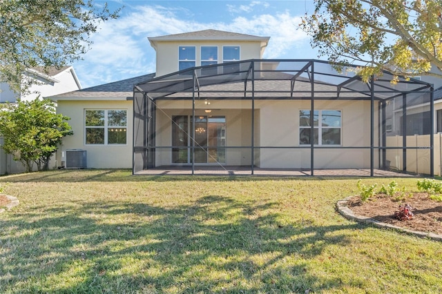 rear view of house with central AC unit, glass enclosure, a patio area, and a lawn