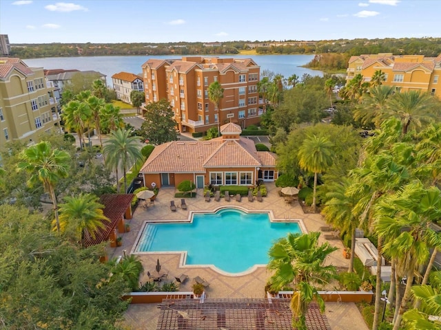 view of pool featuring a water view and a patio area