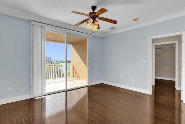 unfurnished room featuring ceiling fan, ornamental molding, and dark wood-type flooring