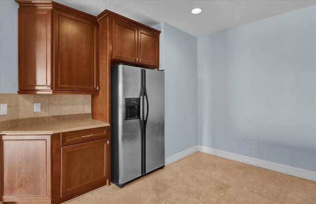 kitchen with decorative backsplash and stainless steel fridge with ice dispenser