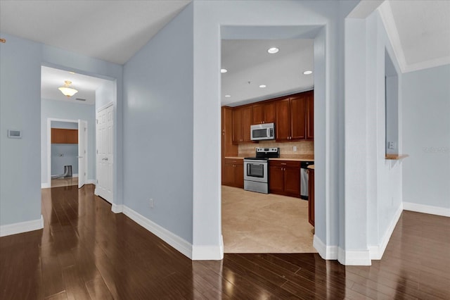 kitchen featuring tasteful backsplash, hardwood / wood-style flooring, and appliances with stainless steel finishes