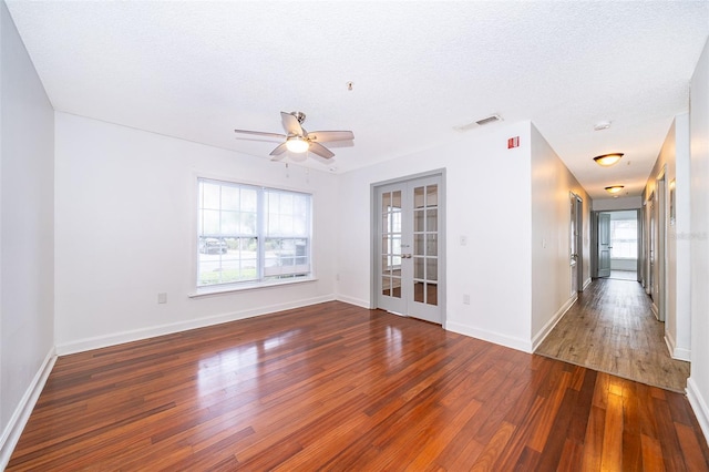 spare room featuring french doors, a textured ceiling, dark hardwood / wood-style floors, and ceiling fan