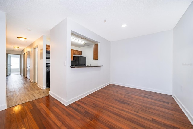 interior space featuring a textured ceiling and dark hardwood / wood-style floors