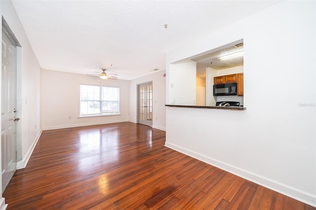 unfurnished living room featuring ceiling fan, french doors, wood-type flooring, and a textured ceiling