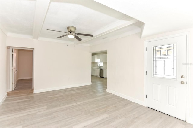 unfurnished room featuring light wood finished floors, baseboards, ceiling fan, a sink, and beam ceiling