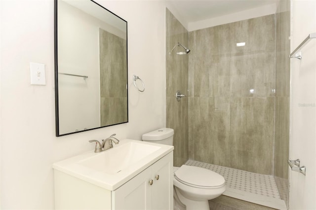 bathroom with toilet, a shower stall, and vanity