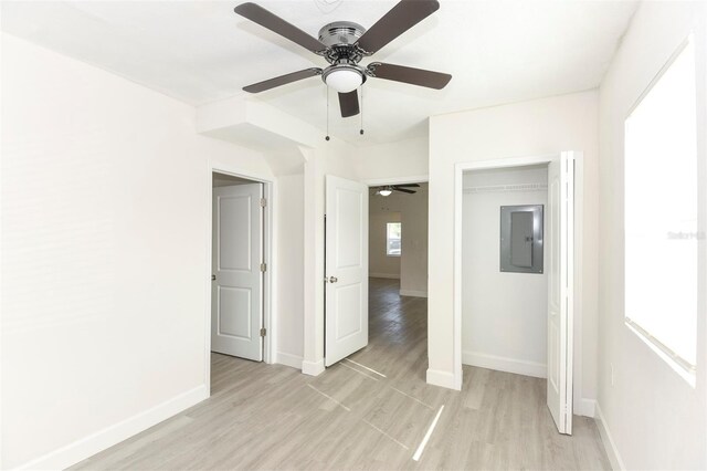 spare room featuring light wood-style flooring, electric panel, and baseboards