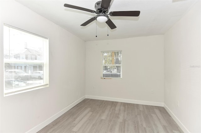 spare room featuring light wood-style flooring, baseboards, and a ceiling fan