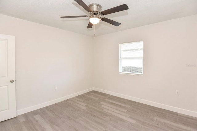 spare room with light wood-type flooring, ceiling fan, and baseboards