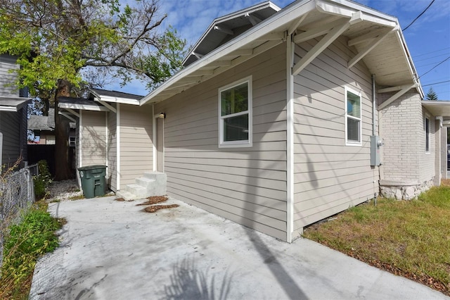 view of side of property with entry steps, a patio area, and fence