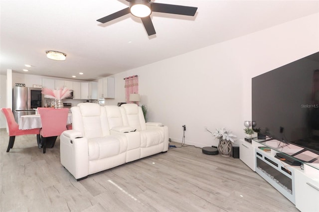 living room featuring ceiling fan and light wood-type flooring