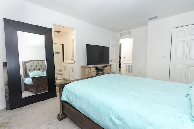 carpeted bedroom with ensuite bathroom and a closet