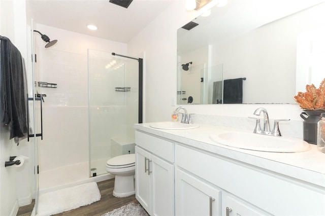 bathroom with vanity, toilet, an enclosed shower, and wood-type flooring