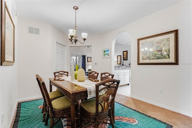 carpeted dining area featuring a notable chandelier