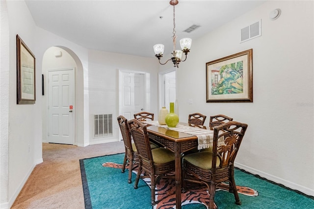 dining room featuring carpet and a notable chandelier