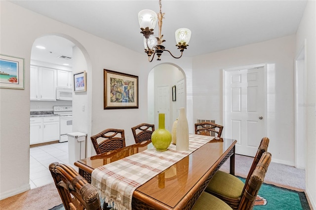 dining area with light tile patterned floors and an inviting chandelier