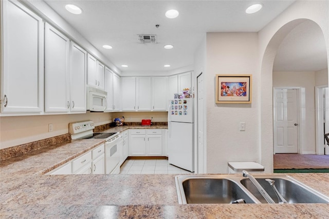 kitchen with light tile patterned floors, white appliances, white cabinetry, and sink