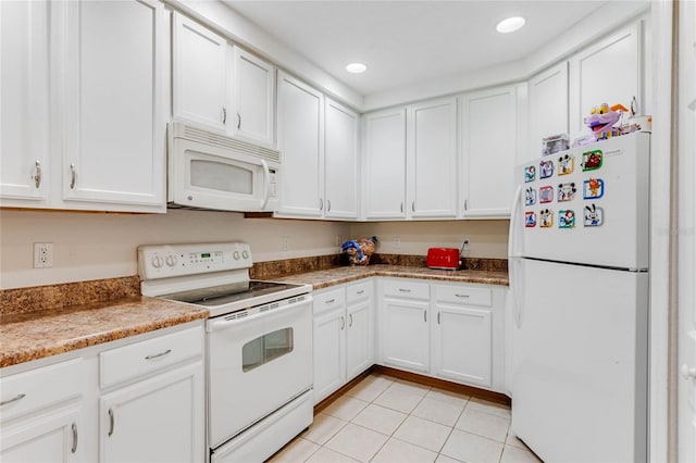 kitchen with light stone counters, light tile patterned floors, white cabinets, and white appliances