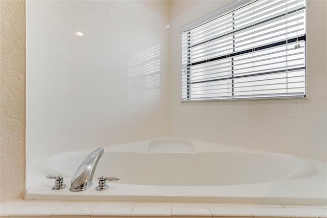 bathroom with plenty of natural light and a relaxing tiled tub