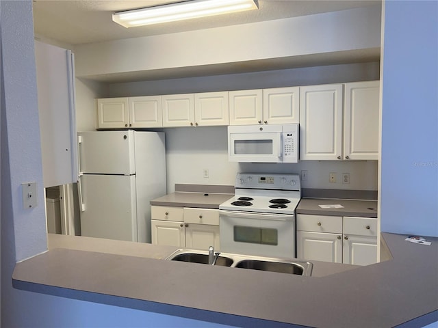 kitchen featuring white appliances, white cabinetry, and sink