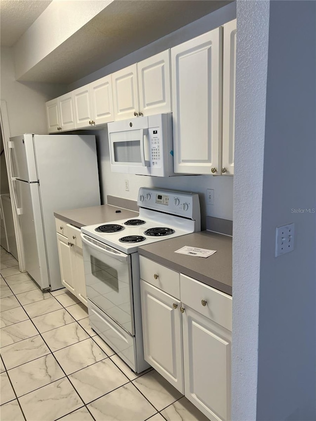 kitchen with white cabinetry and white appliances