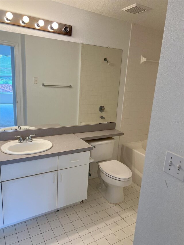 full bathroom featuring tile patterned flooring, a textured ceiling, toilet, vanity, and tiled shower / bath