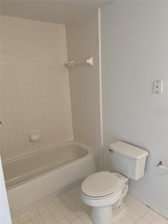 bathroom featuring tile patterned floors, toilet, and tiled shower / bath