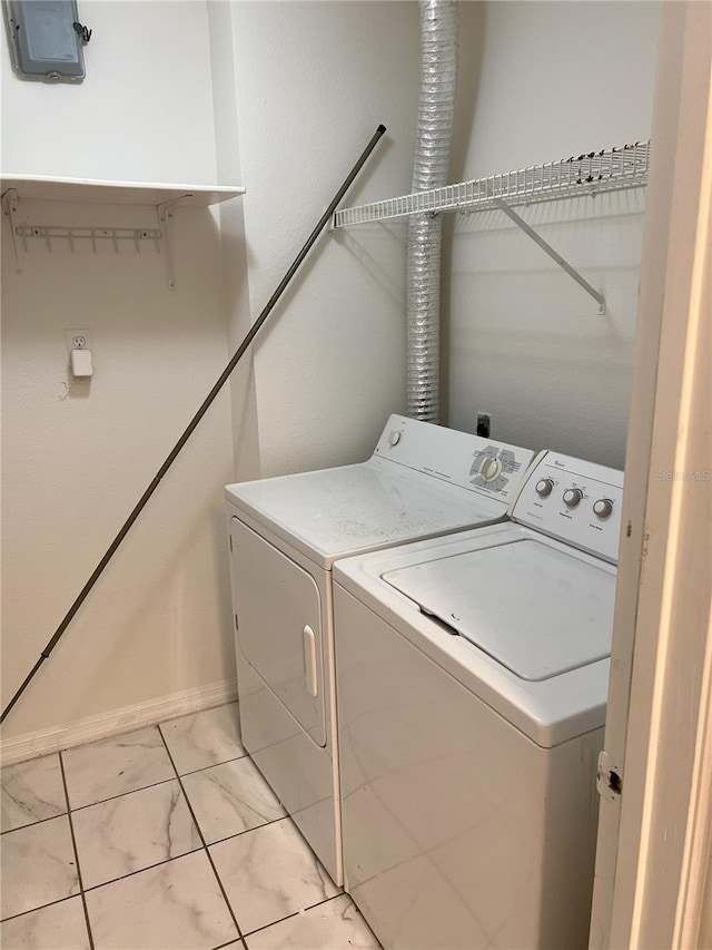 clothes washing area with washer and clothes dryer and light tile patterned flooring