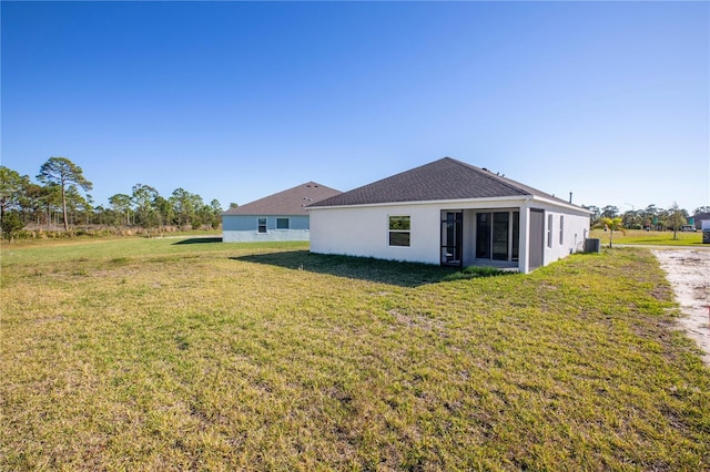 rear view of property with a sunroom and a yard