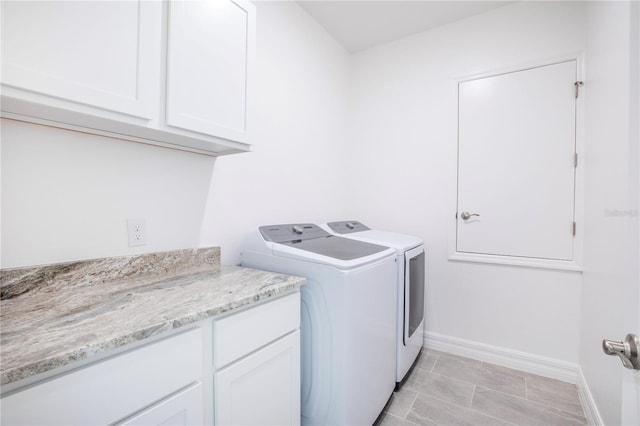 laundry area with washer and dryer and cabinets