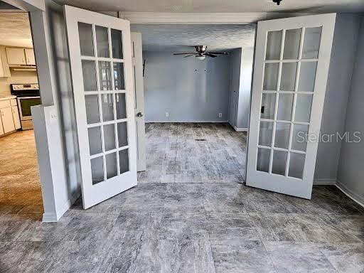 interior space featuring french doors, ceiling fan, and baseboards