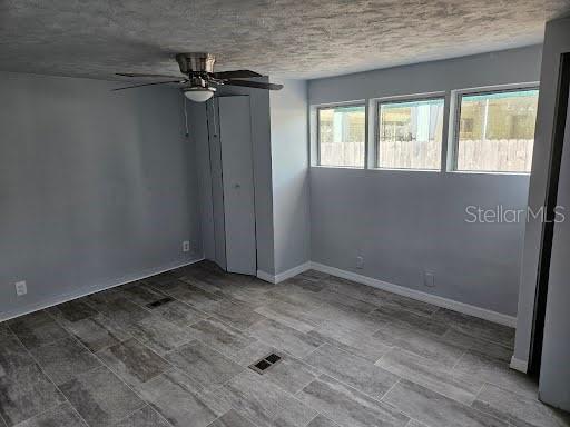 spare room featuring ceiling fan and a textured ceiling