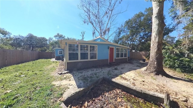 view of side of home with a fenced backyard and a lawn