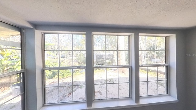 doorway to outside featuring a textured ceiling