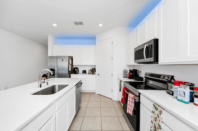 kitchen with light tile patterned floors, white cabinetry, sink, and appliances with stainless steel finishes