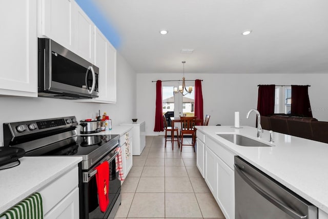 kitchen with sink, stainless steel appliances, an inviting chandelier, decorative light fixtures, and light tile patterned flooring