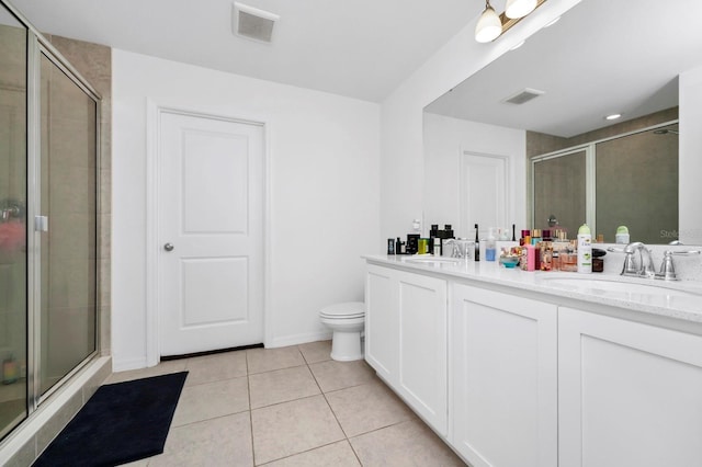 bathroom with tile patterned floors, vanity, an enclosed shower, and toilet