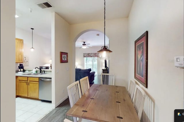 dining area with ceiling fan, light hardwood / wood-style floors, and sink