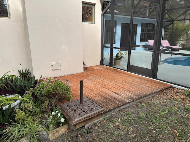 view of patio featuring glass enclosure and a swimming pool side deck