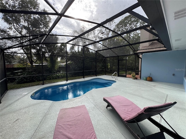 view of pool featuring glass enclosure and a patio