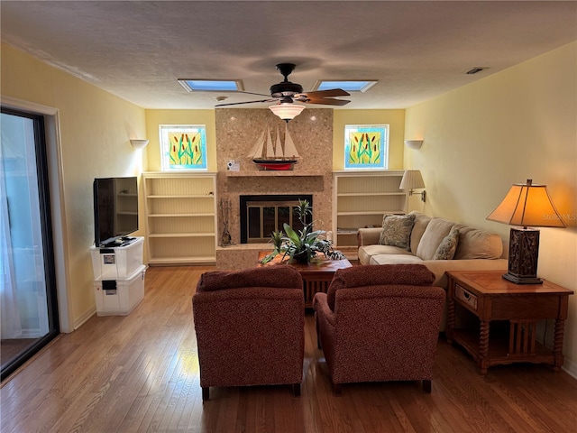 living room with a high end fireplace, hardwood / wood-style floors, and ceiling fan