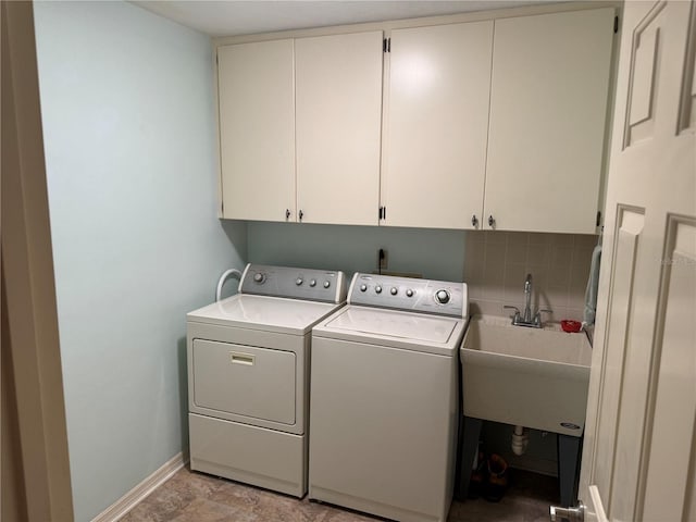 laundry area featuring separate washer and dryer, sink, and cabinets