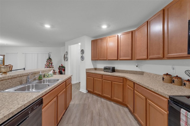 kitchen with dishwashing machine, light hardwood / wood-style floors, and sink